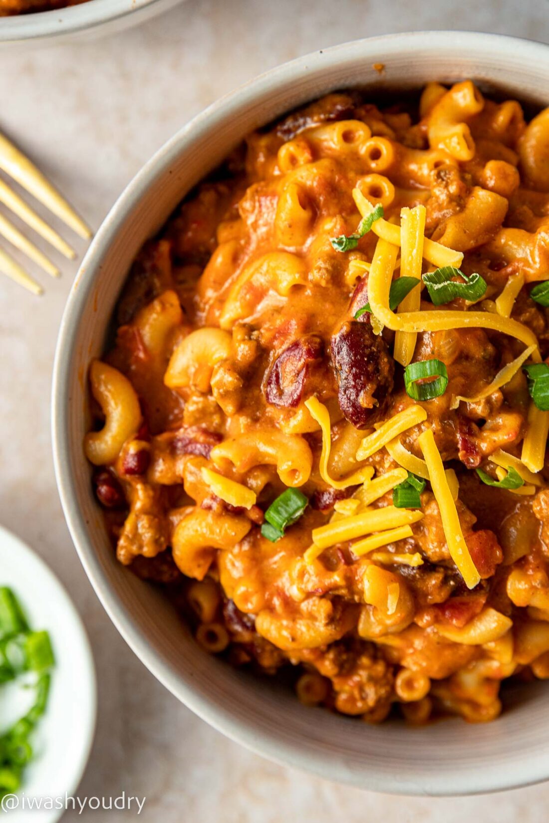 Bowl of macaroni noodles and ground beef with beans in sauce.