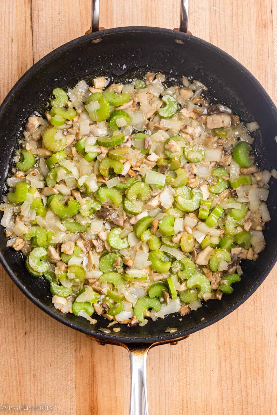 Cooked onion celery and mushroom in a frying pan. 