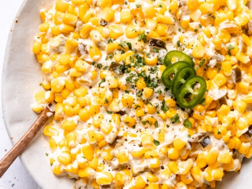 Cooked slow cooker creamed corn in a hwite bowl.