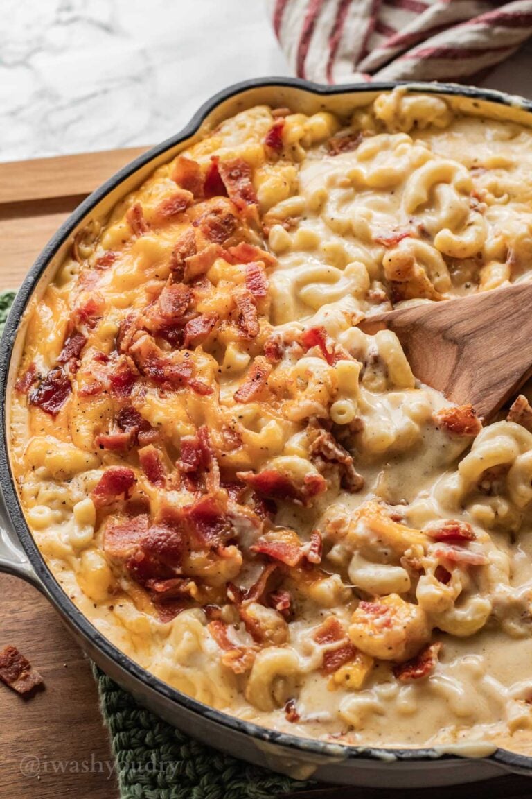 Baked Bacon Mac and Cheese in frying pan with wooden spoon.