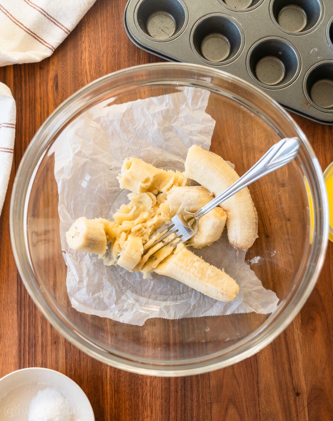 mashed bananas in a bowl with fork. 