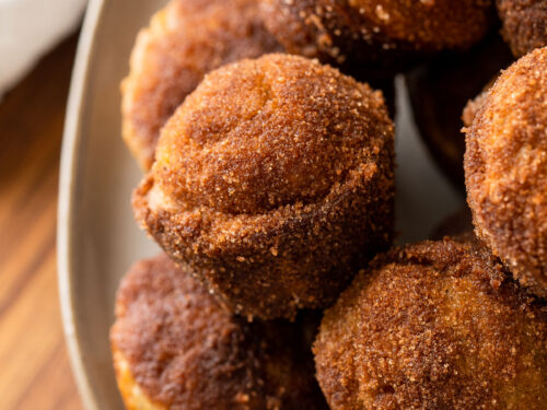 plate full of banana muffins with cinnamon and sugar coating.