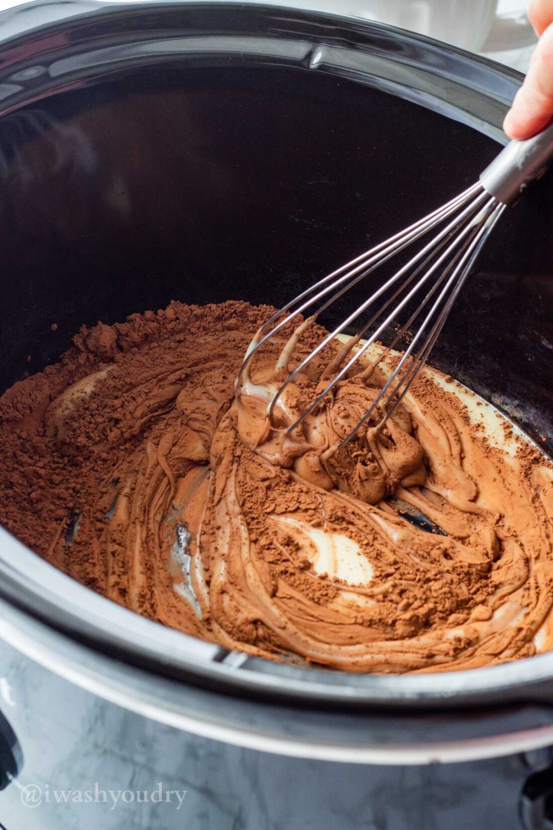 Cocoa Powder, sweet condensed milk, and vanilla with whisk in slow cooker. 