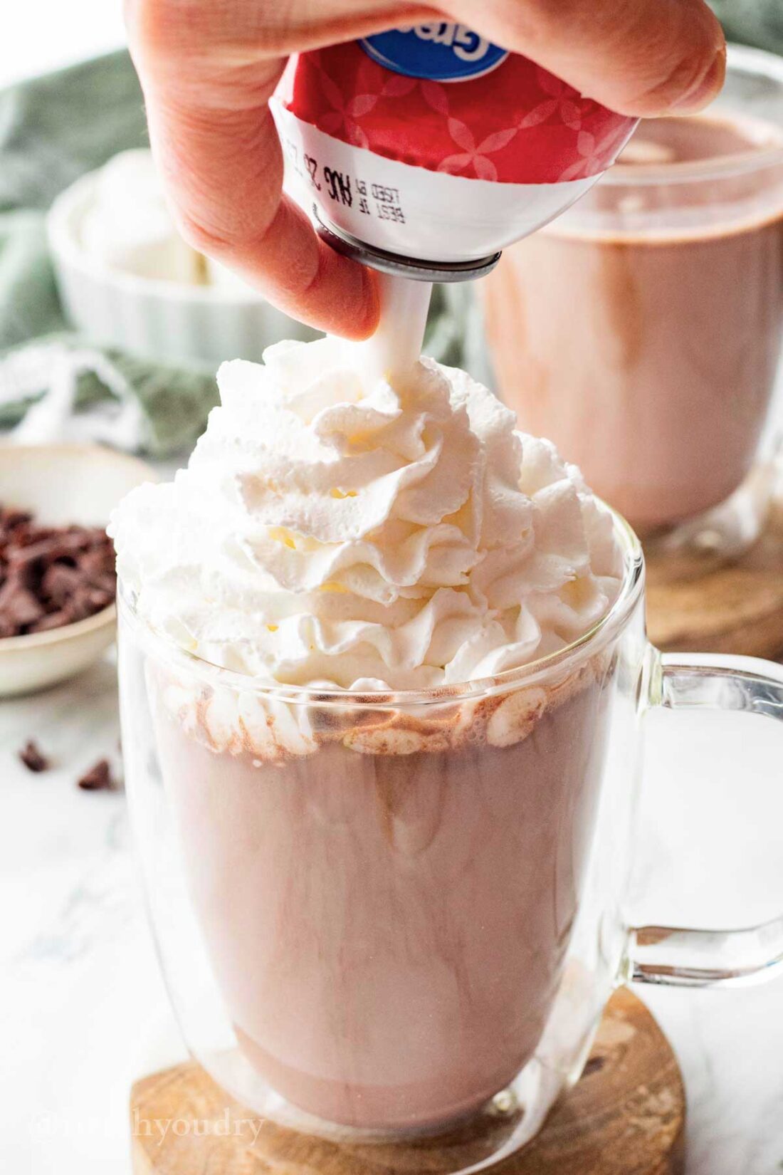 Topping hot chocolate with whipped cream. 