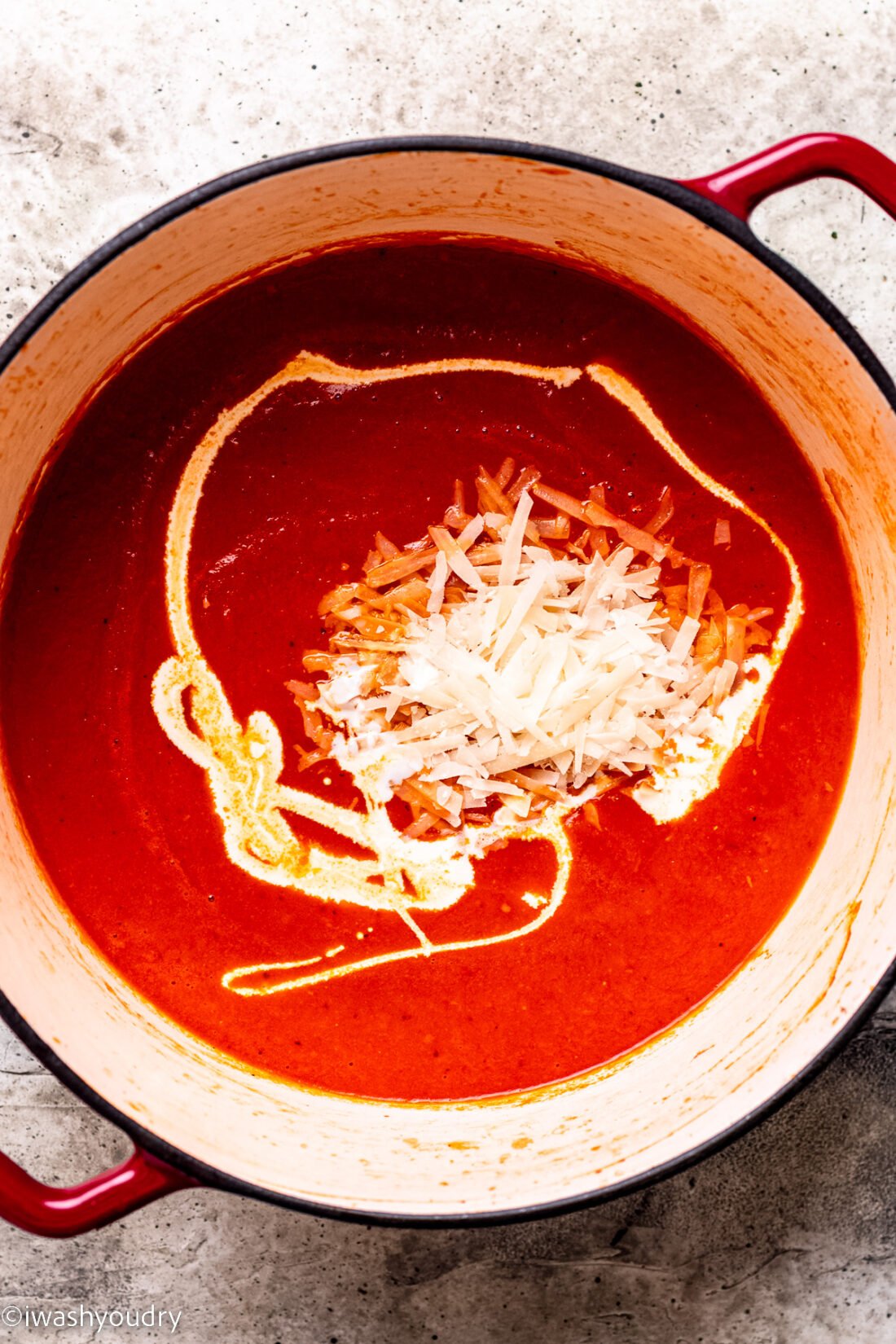pot of tomato soup with heavy cream and parmesan cheese added.