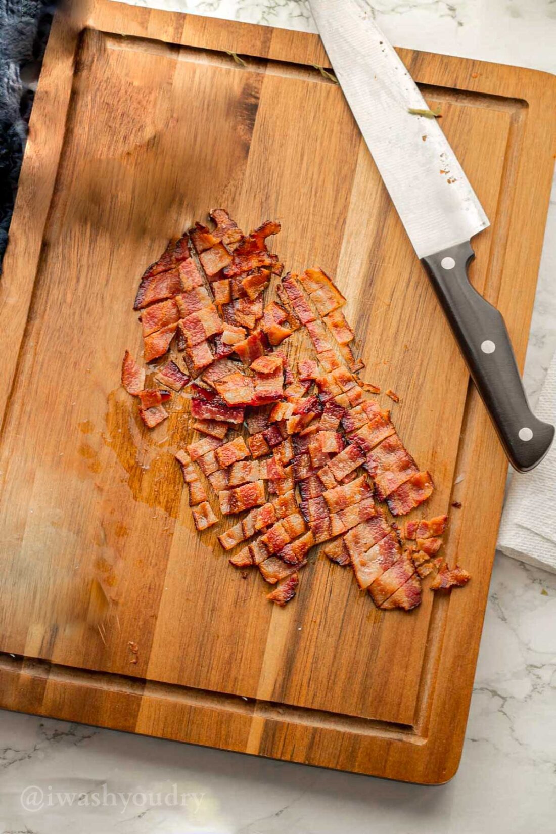 Diced Bacon on a wood cutting board.