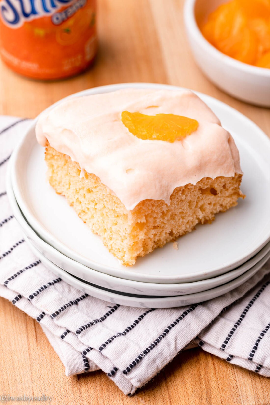 slice of orange crush cake on plate with soda can in backround