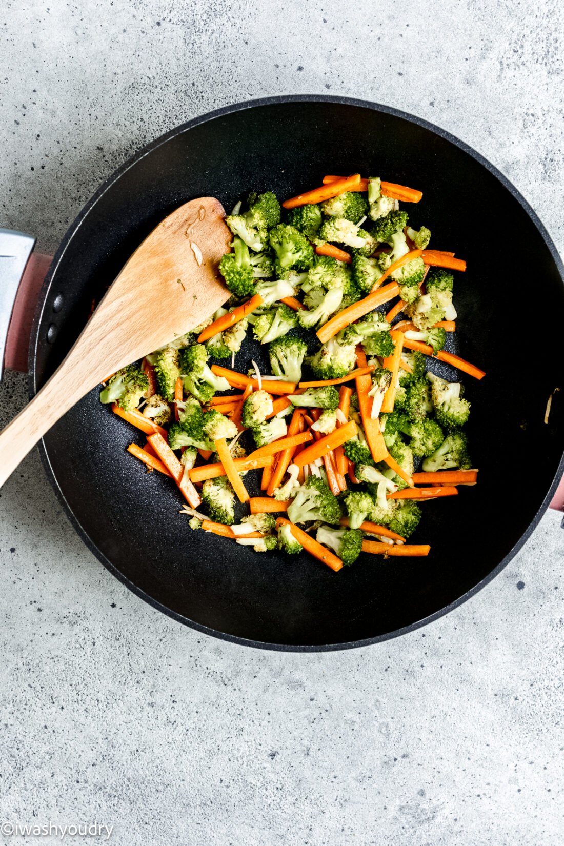 broccoli and carrots in a black wok.