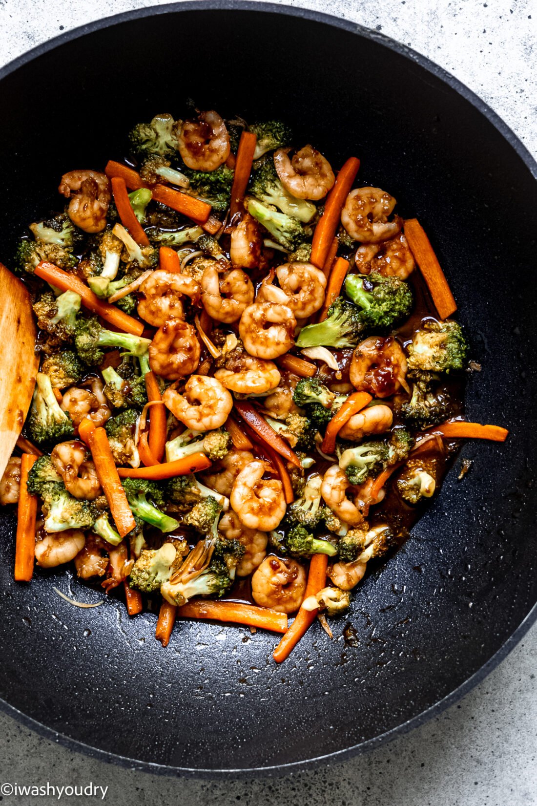 stir fry with broccoli and carrots in large black wok.
