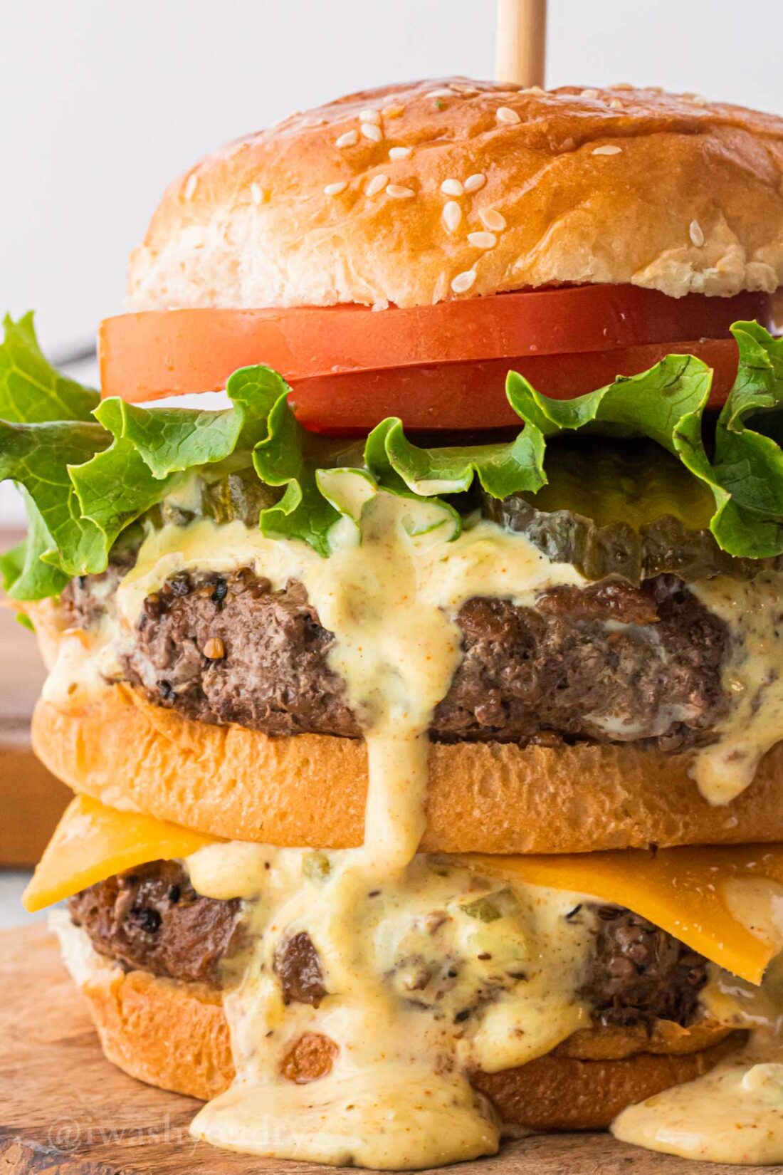 Big Mac Sauce recipe on a juicy hamburger with tomatoes and lettuce.