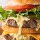 Big Mac Sauce recipe on a juicy hamburger with tomatoes and lettuce.