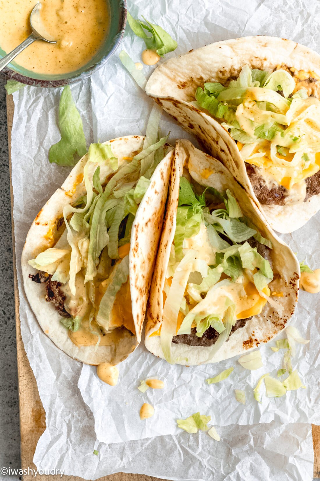 three burger tacos with a side of big mac sauce.
