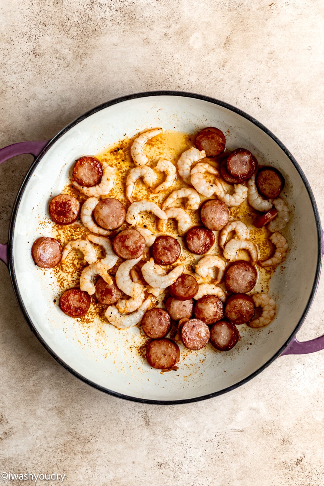 Cooked shrimp and sausage in pan. 