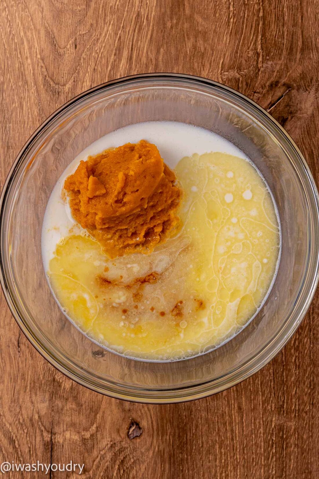 Pumpkin, milk, melted butter, eggs, and vanilla in glass bowl. 