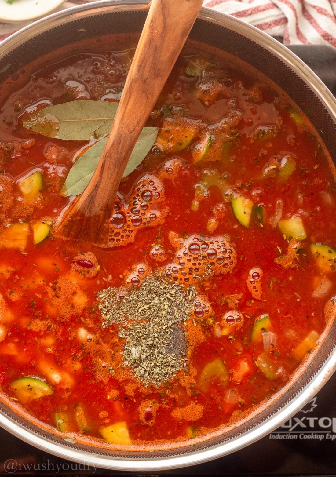 pot of soup with bay leaves on top and seasonings