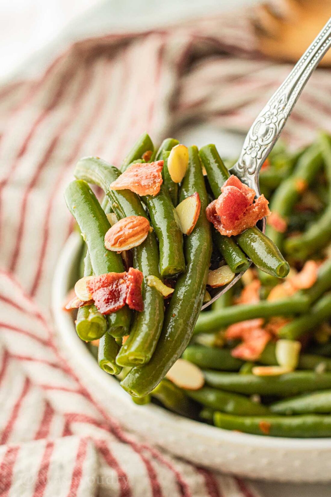 Spoonful of bacon and almond green beans with butter.