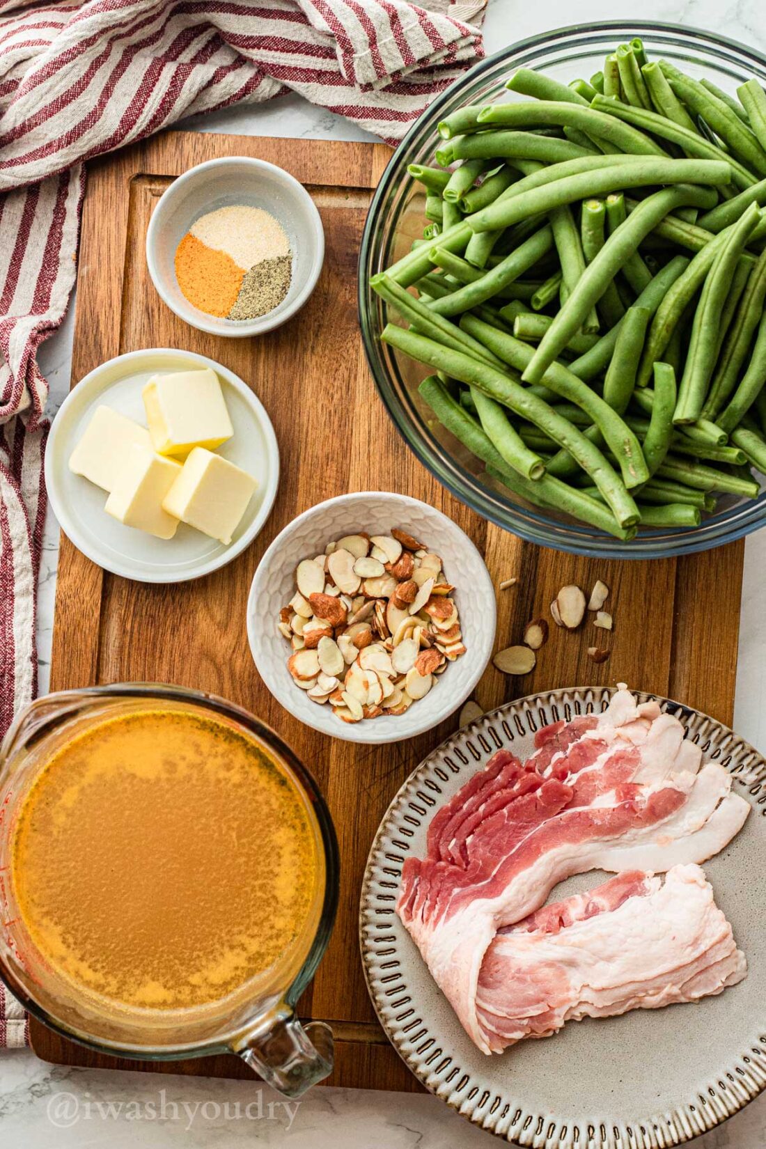 ingredients on wooden surface with bacon and green beans.