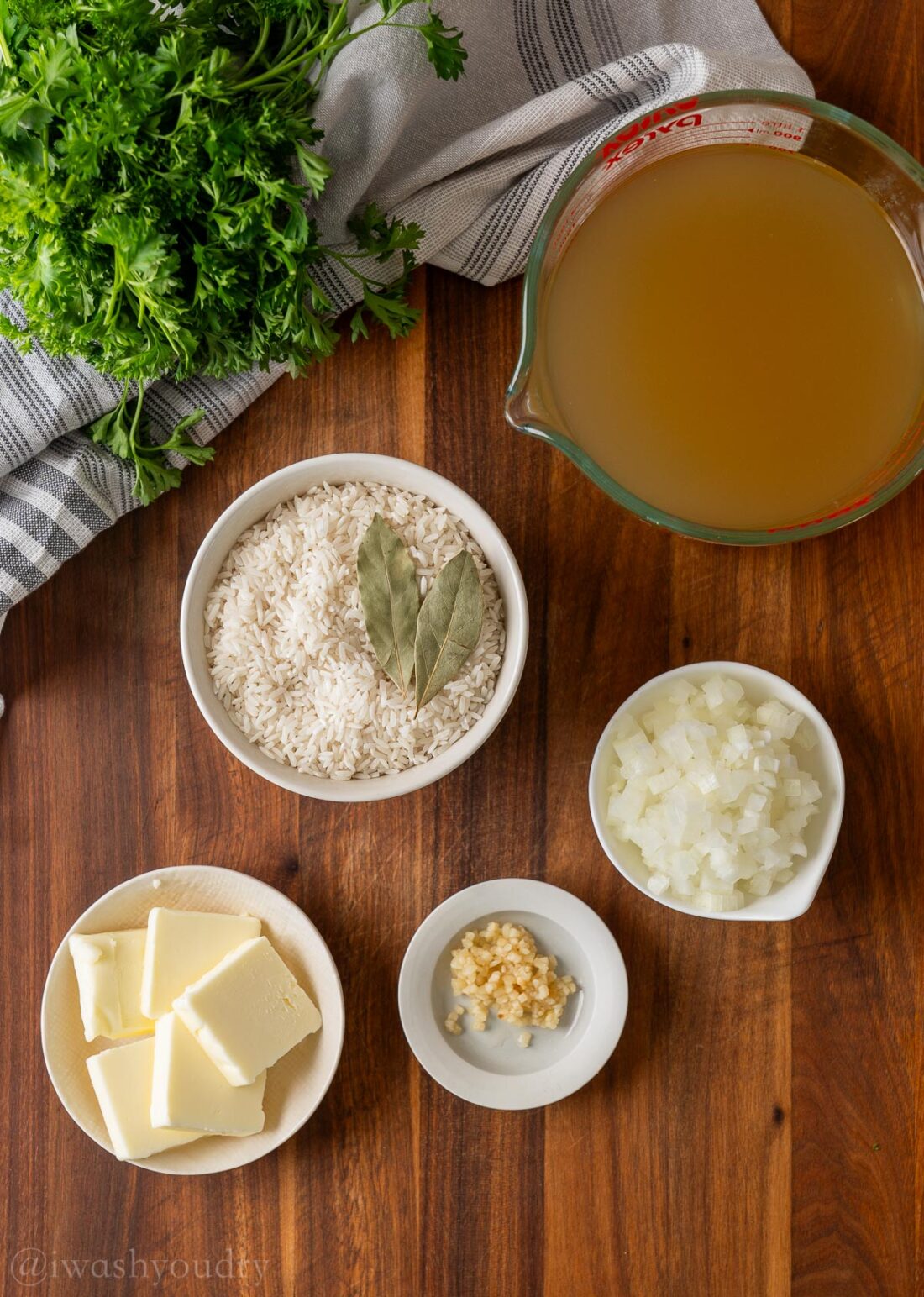 Ingredients for butter rice pilaf on wood cutting board. 