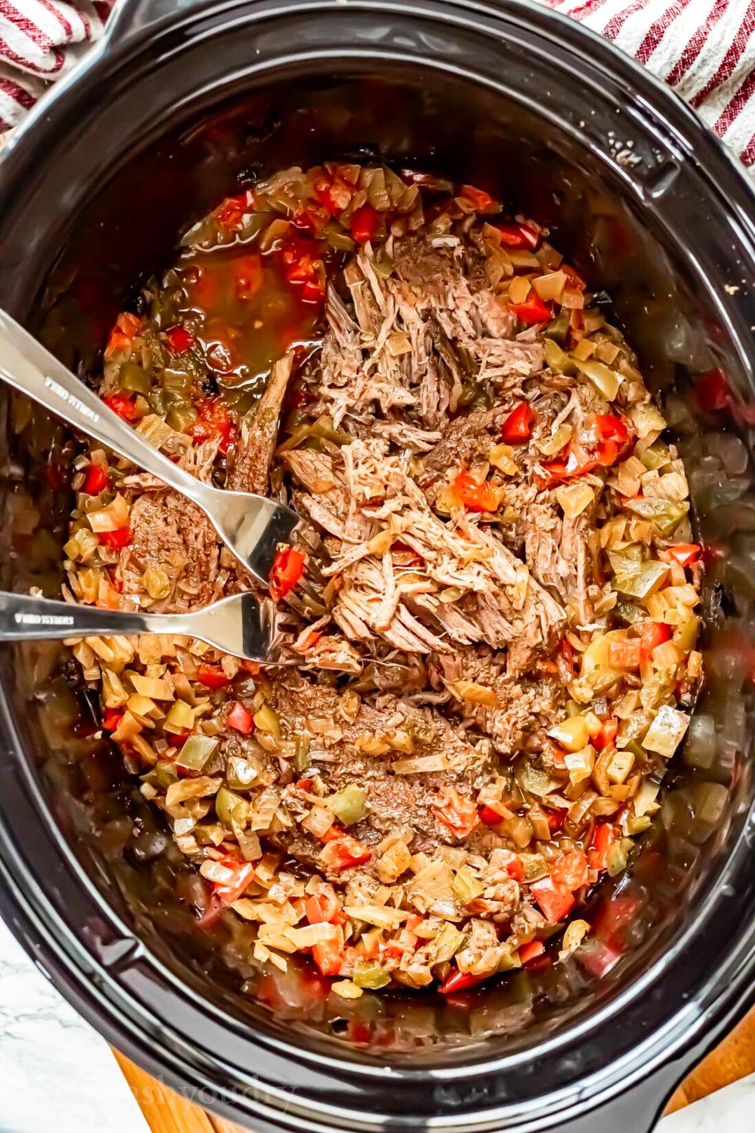 slow cooker shredded beef with two forks.