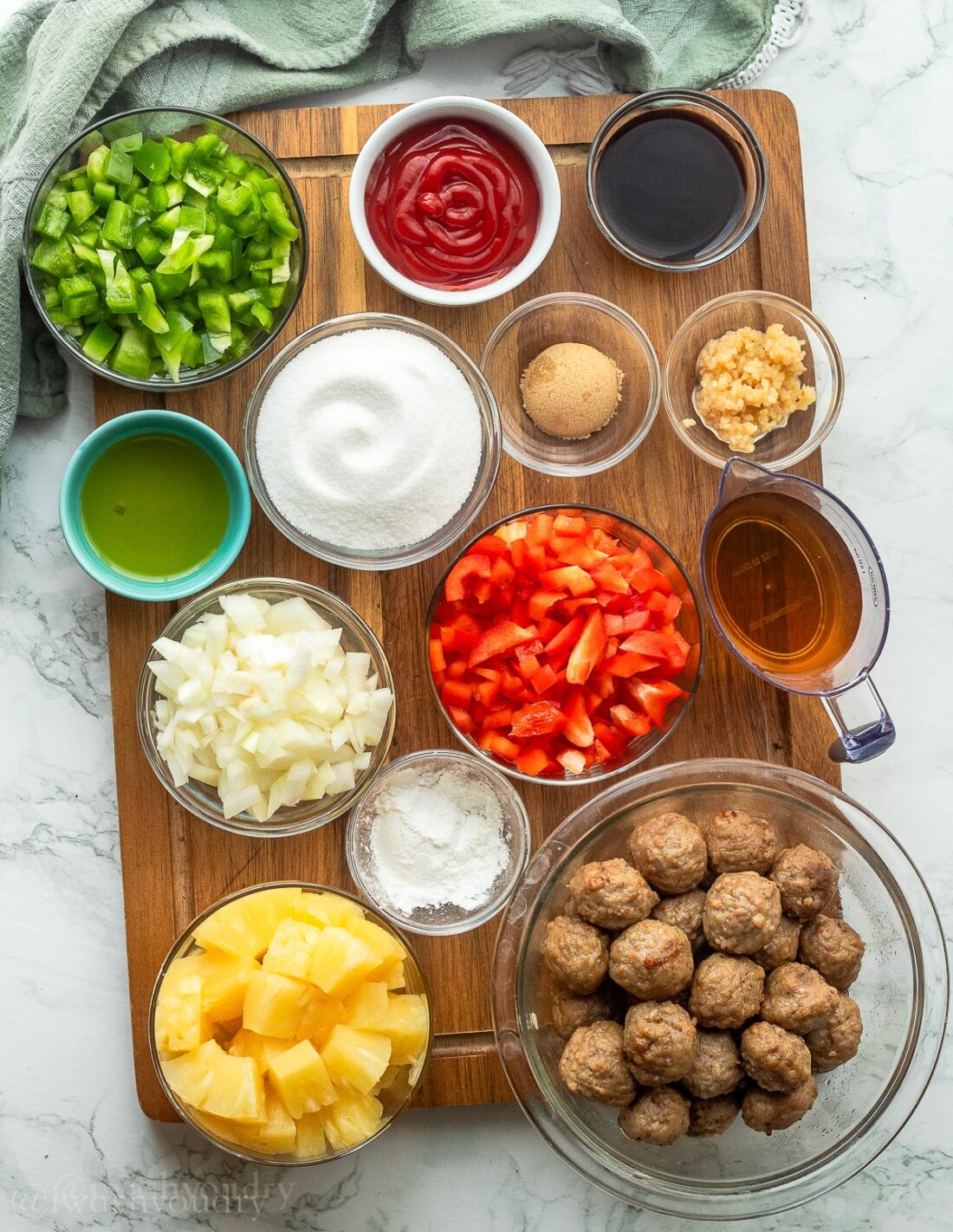 Ingredients for Sweet and sour meatballs on a wood cutting board. 