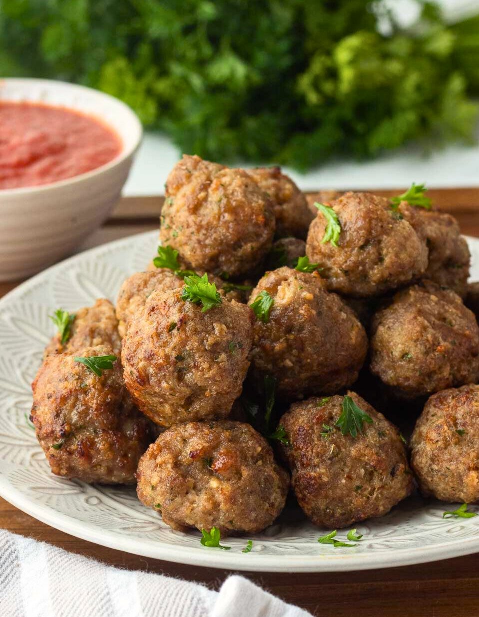 stacked meatballs on a white plate.