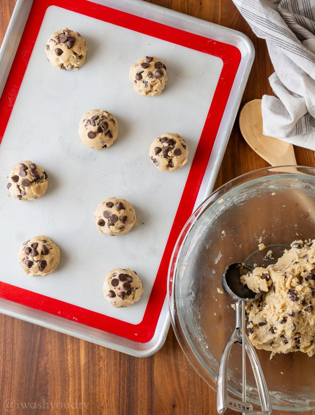 scooped cookie dough balls on silicone lined baking sheet.