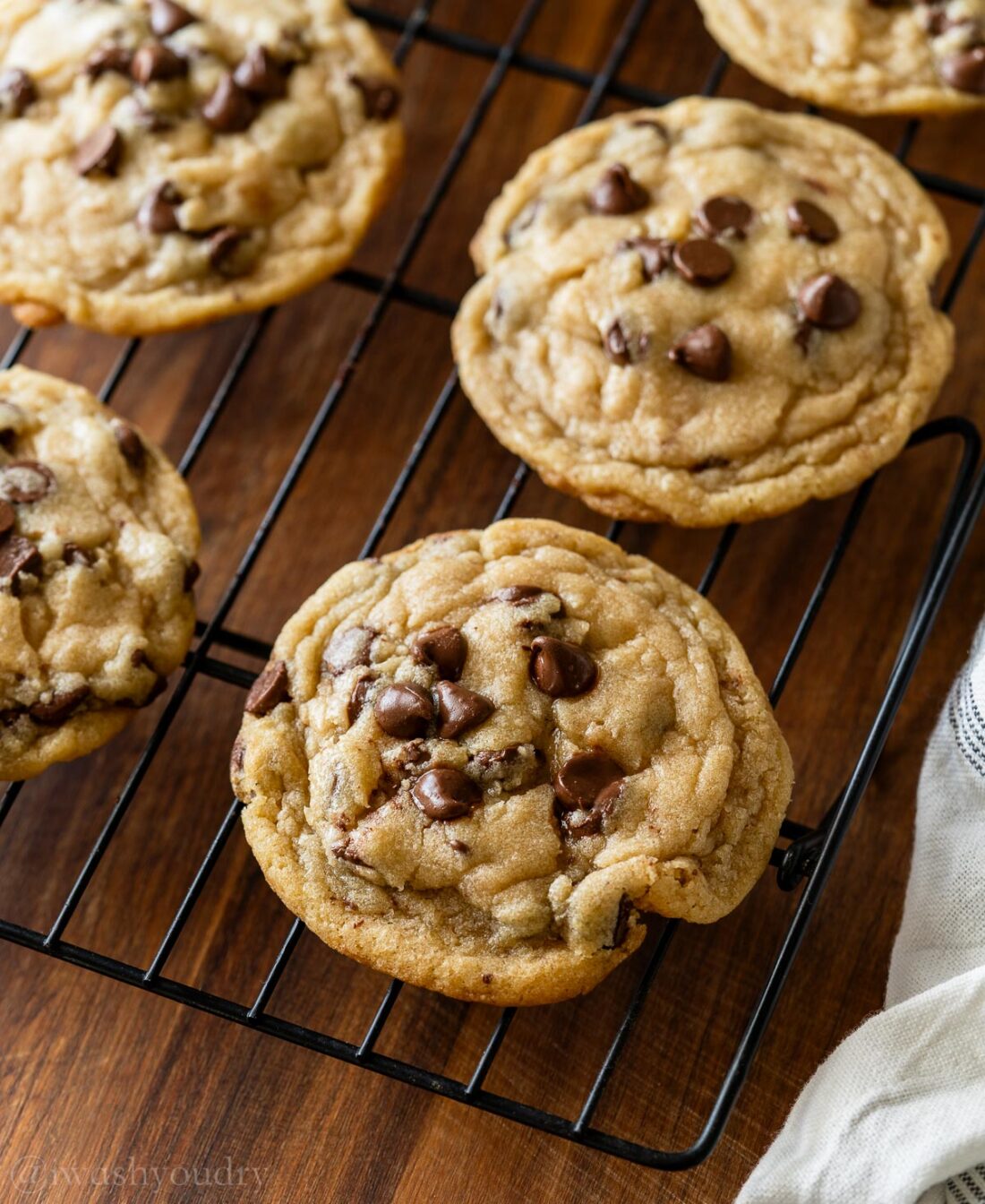 warm chocolate chip cookie on cookie cooling rack.