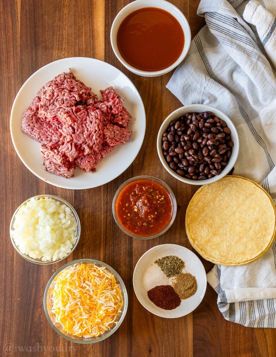 ingredients with ground beef on wooden surface.