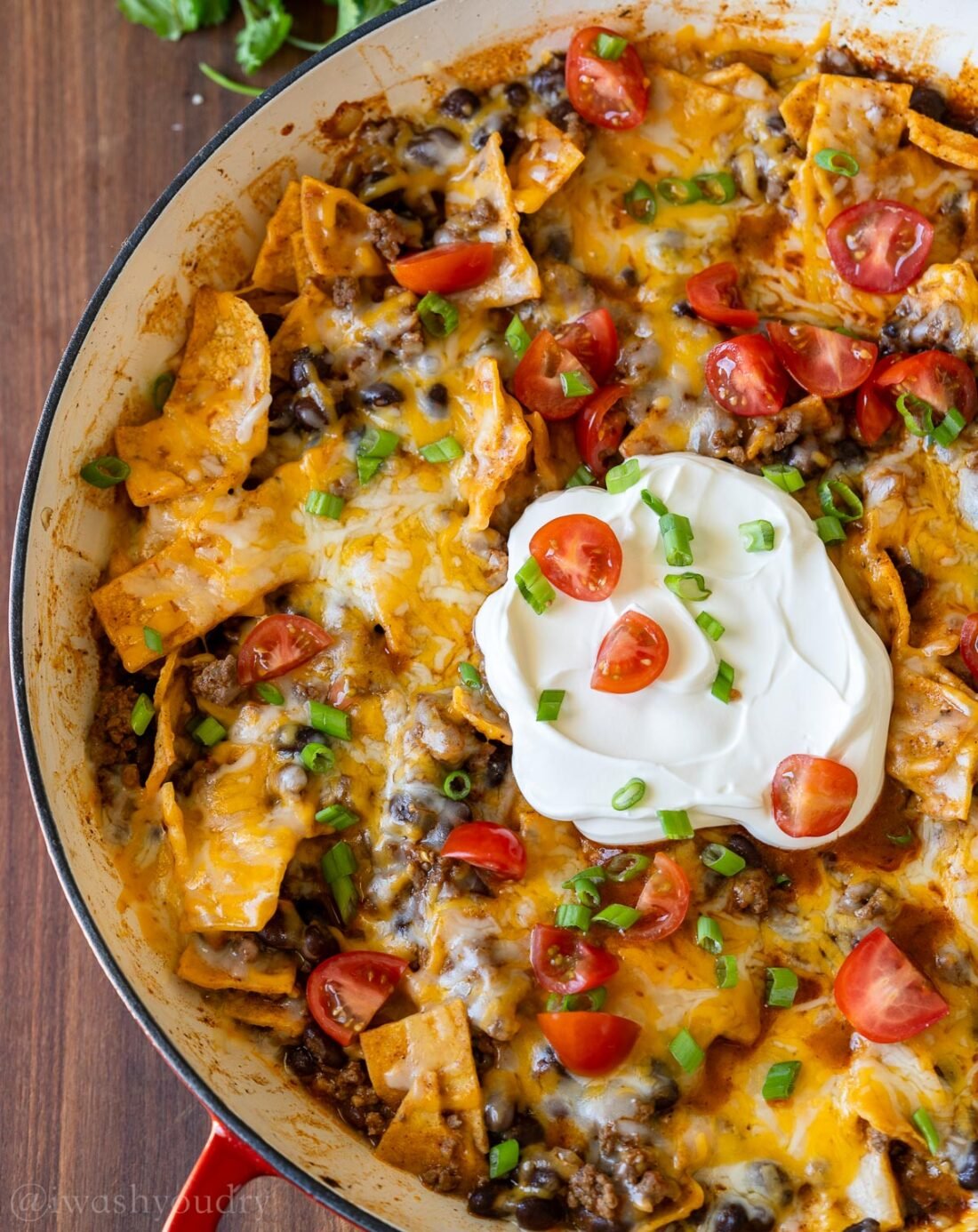 beef enchilada casserole in pan with sour cream.