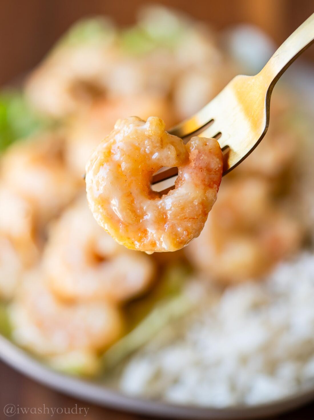 shrimp on a fork with a creamy white sauce.