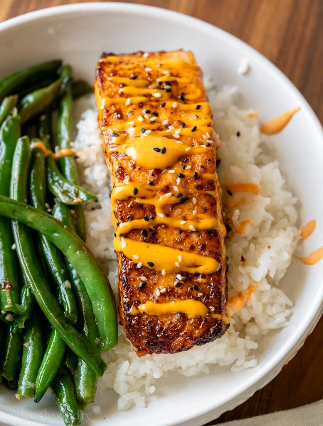 Salmon with spicy sauce on top and sesame seeds