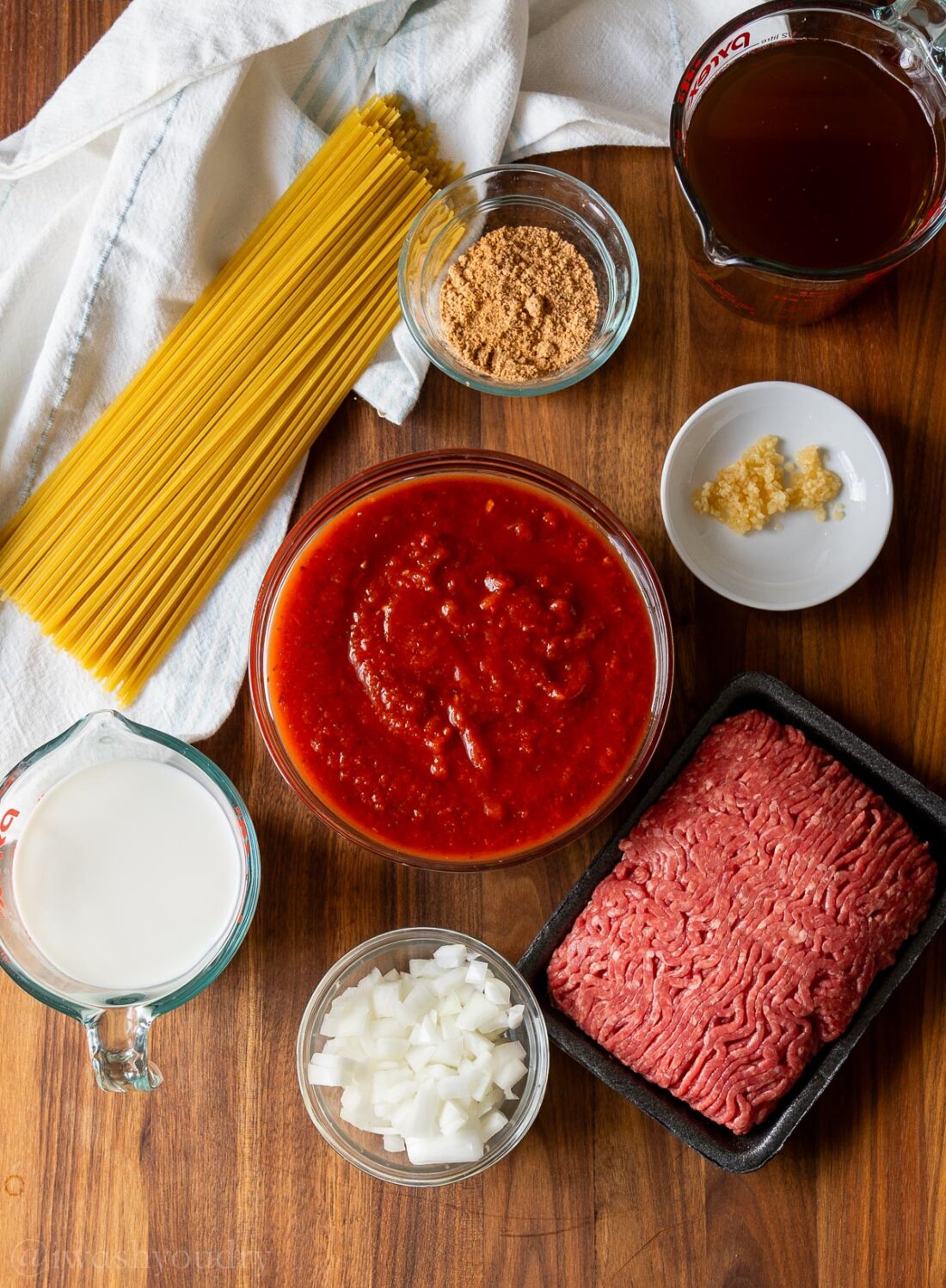 ingredients for taco spaghetti on wooden surface.