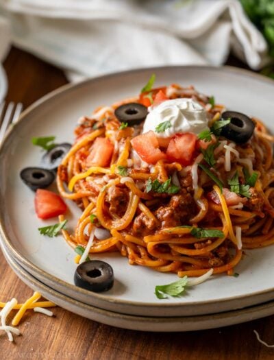 plate of spaghetti with taco meat and toppings.