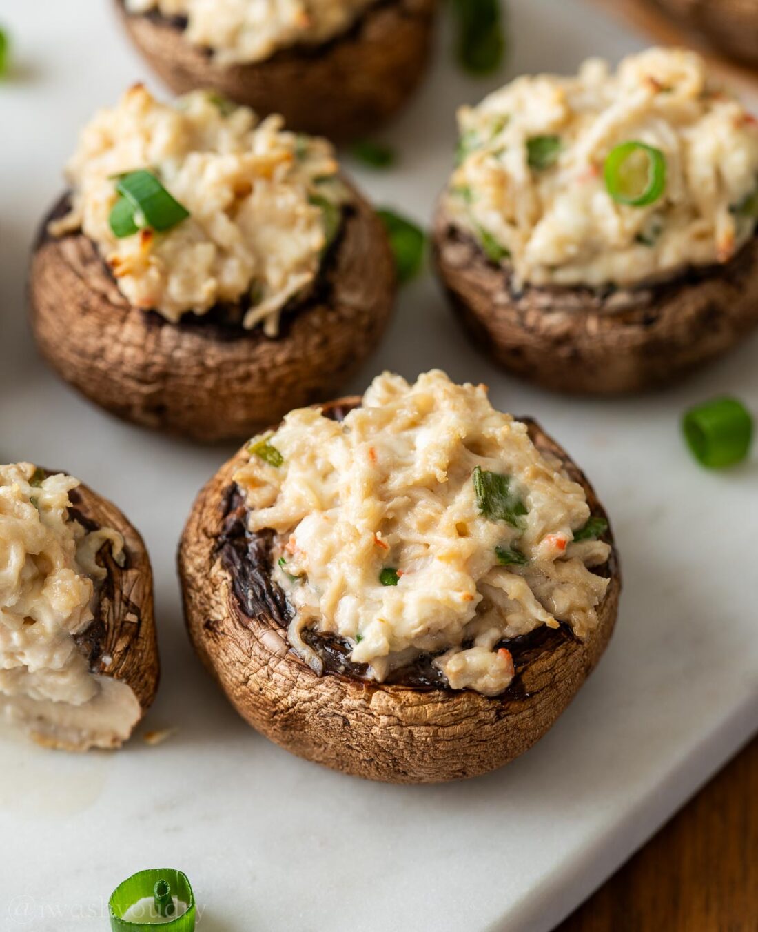 stuffed mushrooms on a white serving platter.