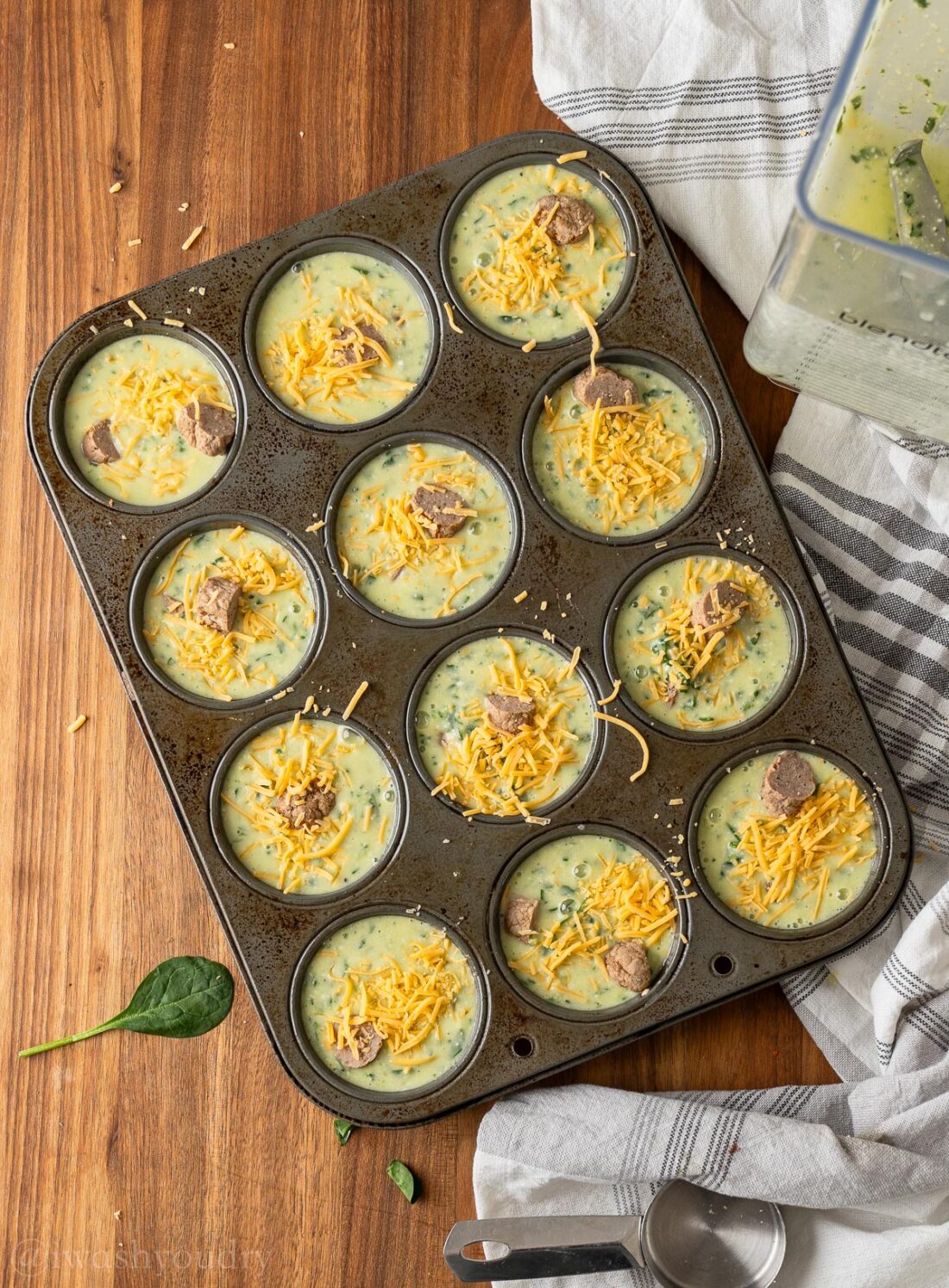 added cheese on top of eggs in muffin tin.