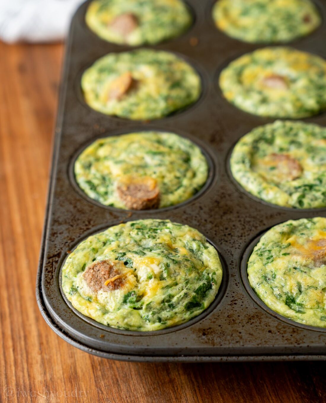 spinach sausage egg bites in pan with cheese.