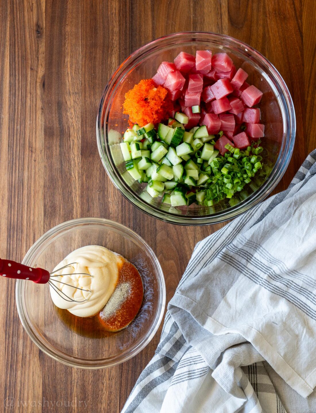 raw tuna in a glass bowl with creamy mayo sauce in another separate bowl.