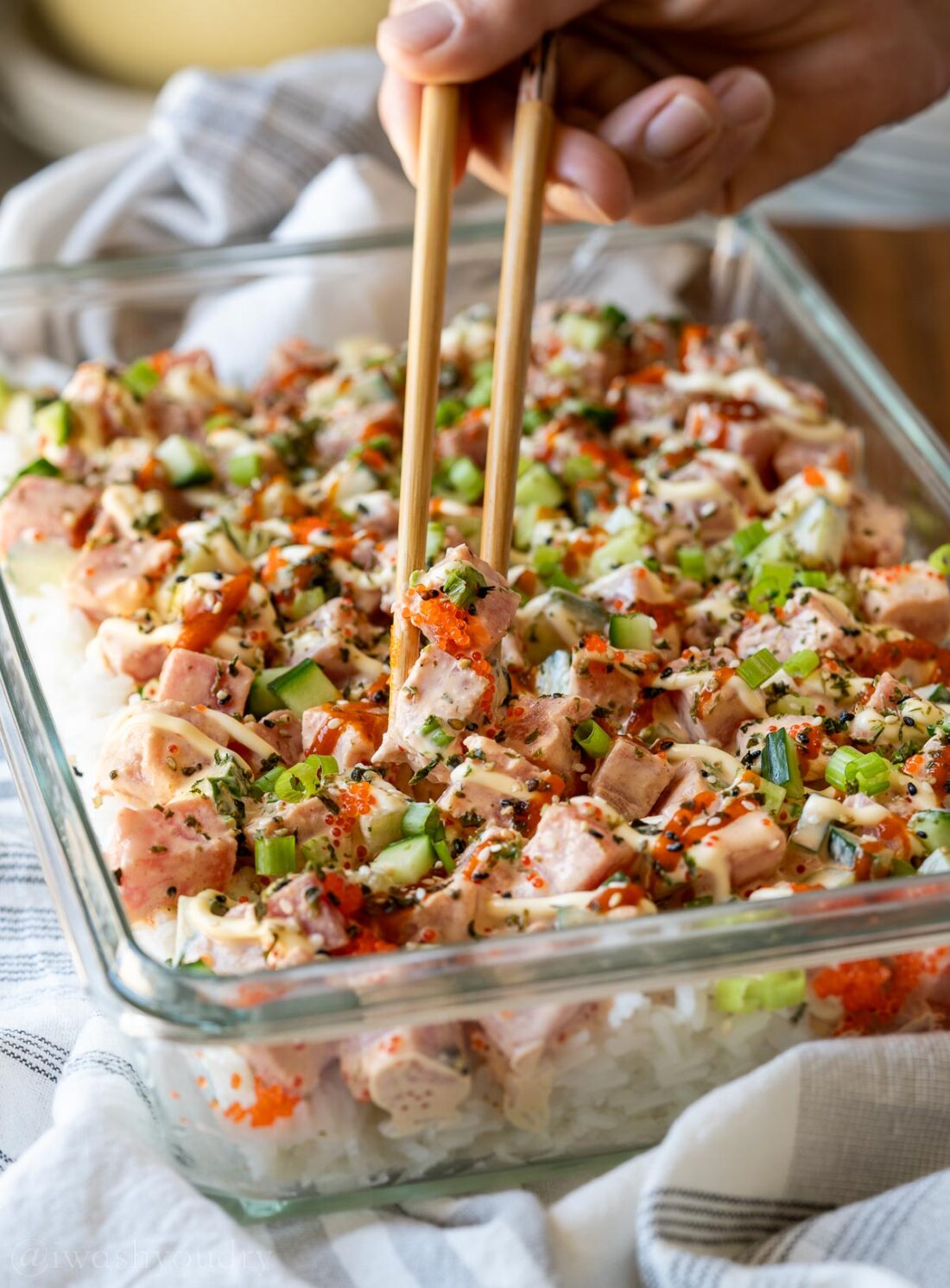 chopsticks taking a portion of tuna from the casserole dish.