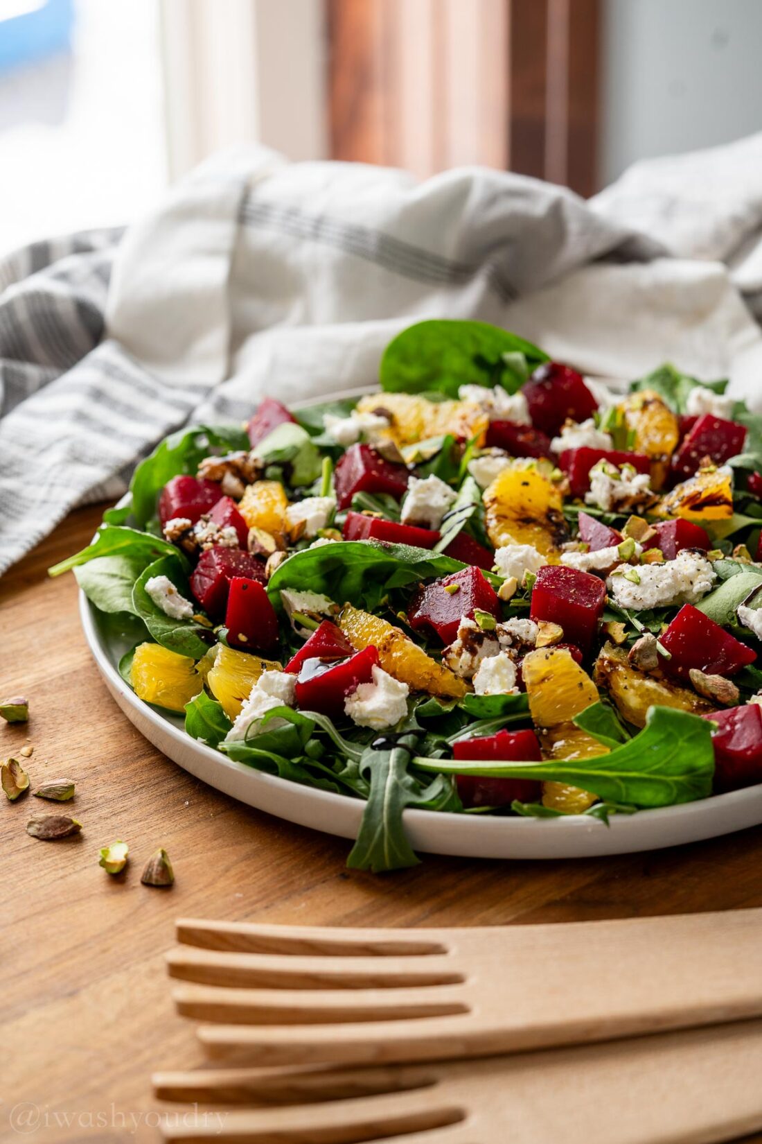 platter filled with beet salad plus goat cheese and pistachios.