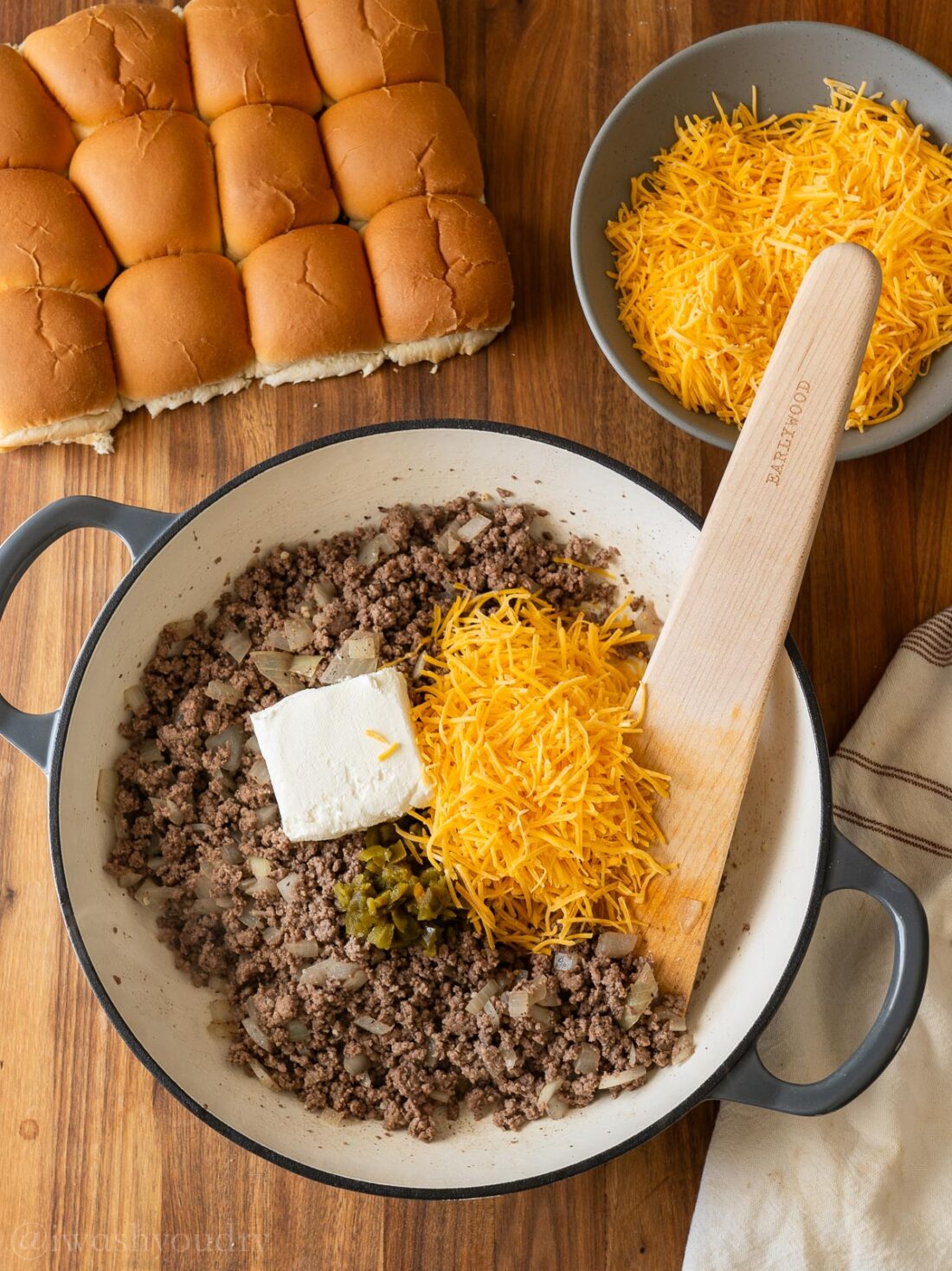 skillet filled with loose ground beef, cream cheese, cheddar cheese and pickled jalapenos.