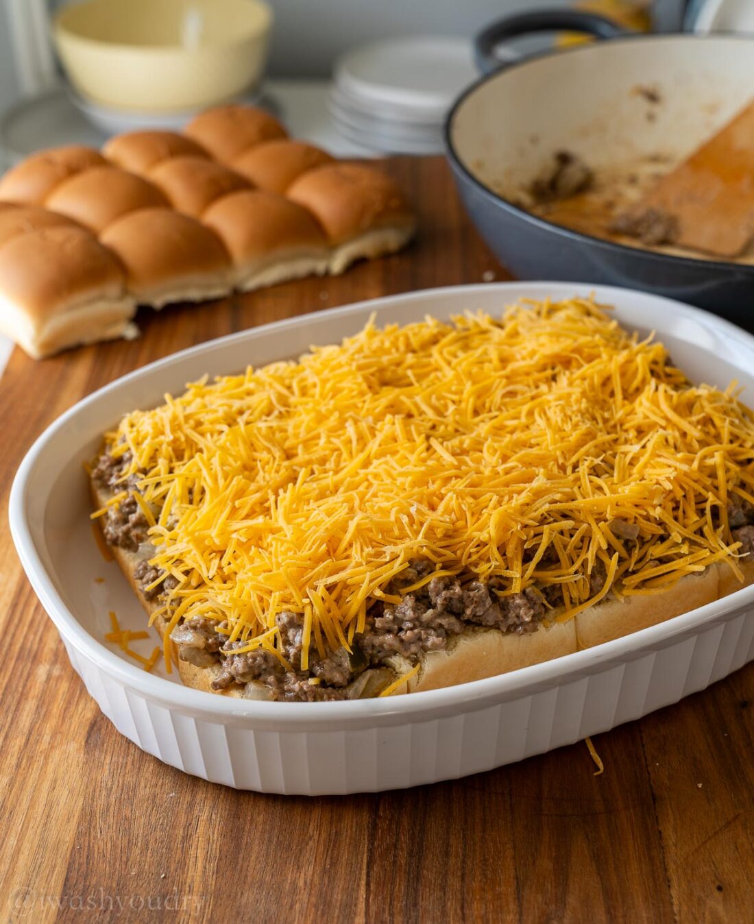 beef mixture topped with cheddar cheese over dinner rolls.