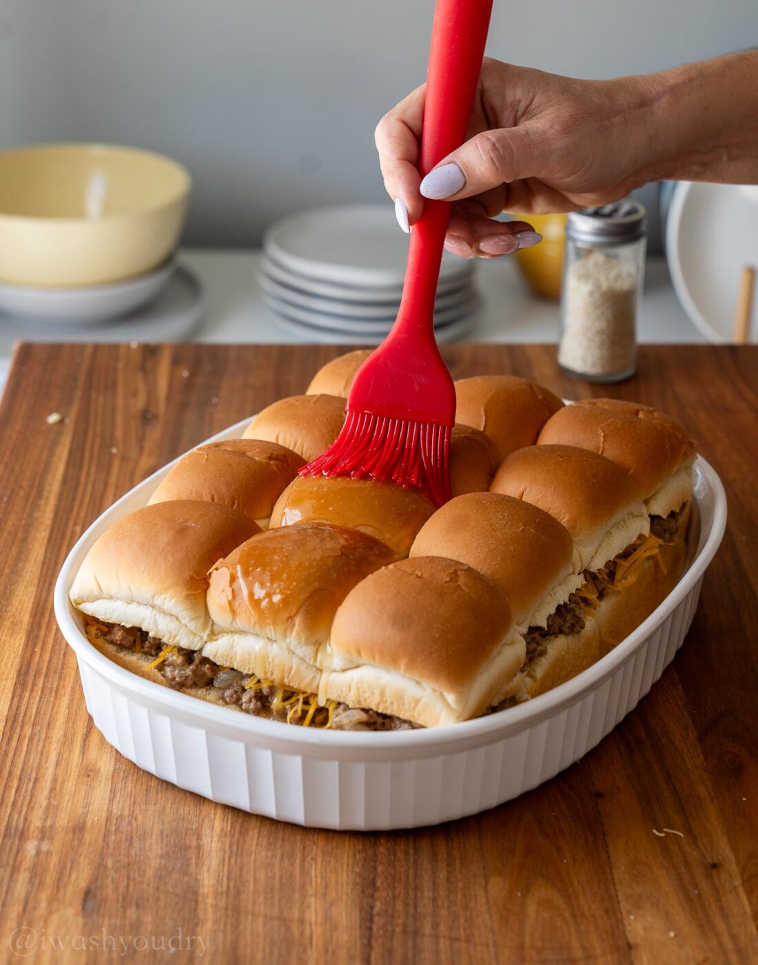 brushing top of buns with garlic butter mixture.