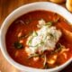 bowl of lasagna soup with ricotta cheese dumpling on top.