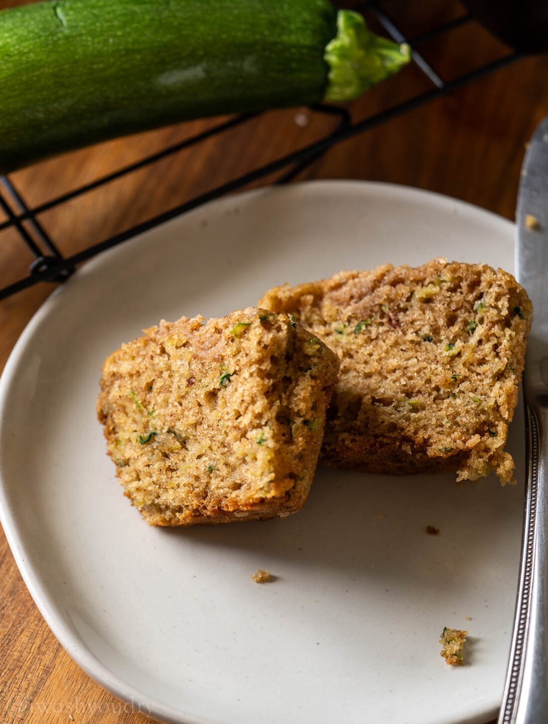 moist zucchini muffins on plate with brown sugar crumb topping.