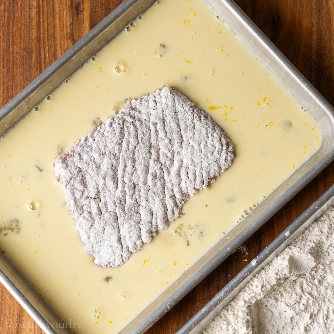 flour coated steak in egg mixture.