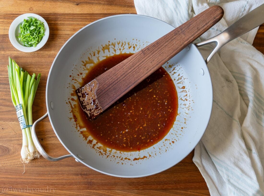 sweet chili sauce in a wok with wooden spoon inside.
