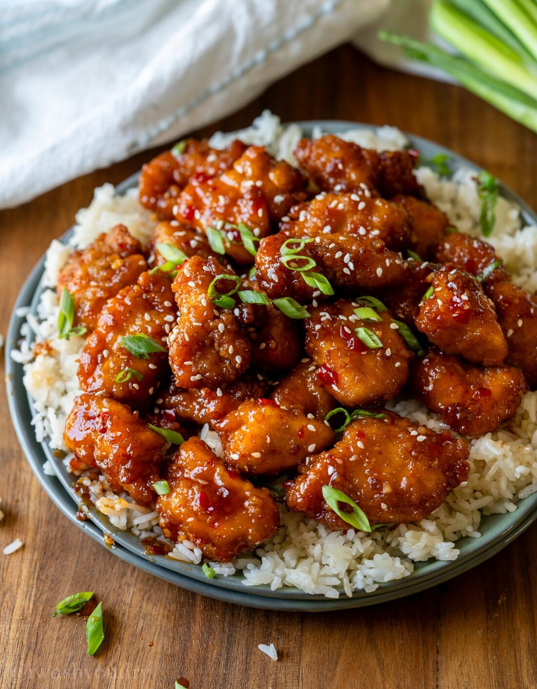 plate of chicken breast bites in a sweet chili sauce served over white rice.