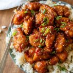 plate with rice and sweet chili chicken on top.