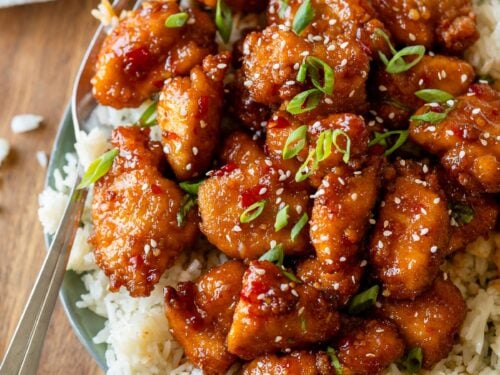 plate with rice and sweet chili chicken on top.