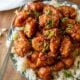 plate with rice and sweet chili chicken on top.
